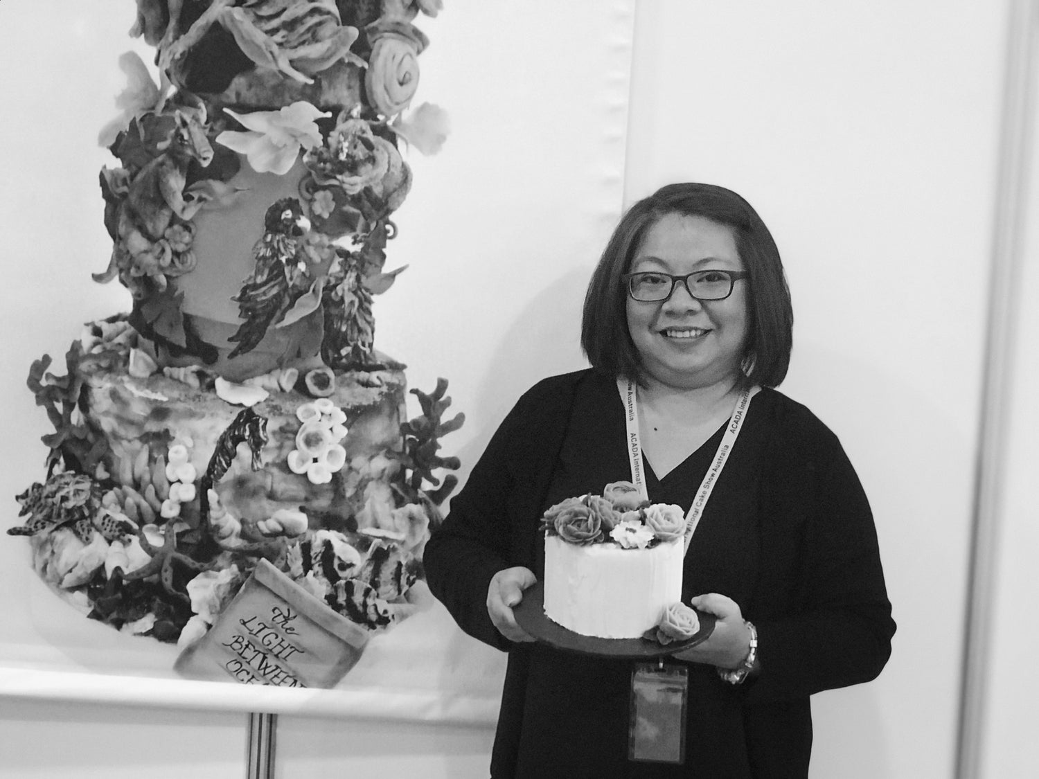 Cake artist holding a floral cake she created
